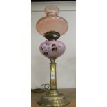 A brass column oil lamp with copper reservoir and etched glass shade.