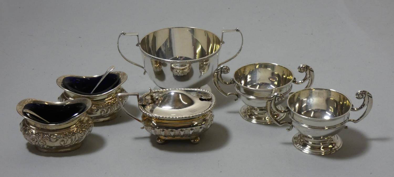 A silver mustard pot, Sheffield 1910, two pairs of silver salt pots and a sugar bowl.