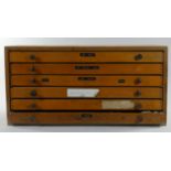 A five drawer wooden printers chest including contents of metal stamps in varied sizes. height 25cm,