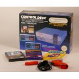 Boxed Nintendo entertainment system with power supply, TV lead, two mini panel controllers, light