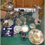 A box of miscellaneous plated ware, including a spirit kettle, chamber sticks, cased and loose