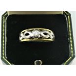 An 18ct yellow and white gold and diamond single stone ring, collet set with a brilliant cut