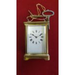 A brass carriage clock, with white enamel dial, the movement striking on a gong.