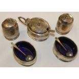 A silver 5 piece cruet set, Birmingham 1932, of oval form, blue glass liners.