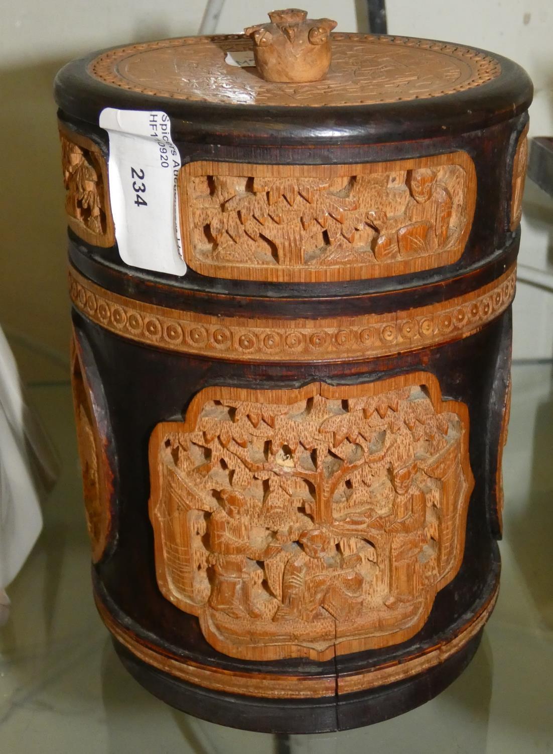 A wooden circular tea caddy, lead lined with carved wooden panels
