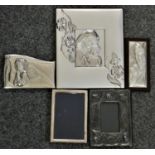 An embossed silver photograph frame, London 1985, 17 x 12 cm, a German silver frame and three