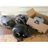 Four motorcycle helmets, for display purposes only.