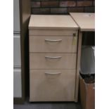 A light beech corner office desk togther with a matching set of lockable three drawer chest of