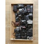 A collection of cameras including a Canon Canonet, a Nikon Af 28-80mm Lens and a Leica Eldia