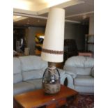 A mid 20th Century ceramic table lamp of bulbous form with raised decoration and large cylindrical