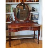 A Victorian mahogany dressing table, with oval swing mirror, the serpentine front with 3 frieze