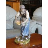 A late 19th Century continental ceramic glazed figure of a woman feeding chicken. 60cm tall.