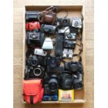 A collection of cameras and accessories including a Cosmorex SE, a Ricoh KR-5 and a Olympus OM101