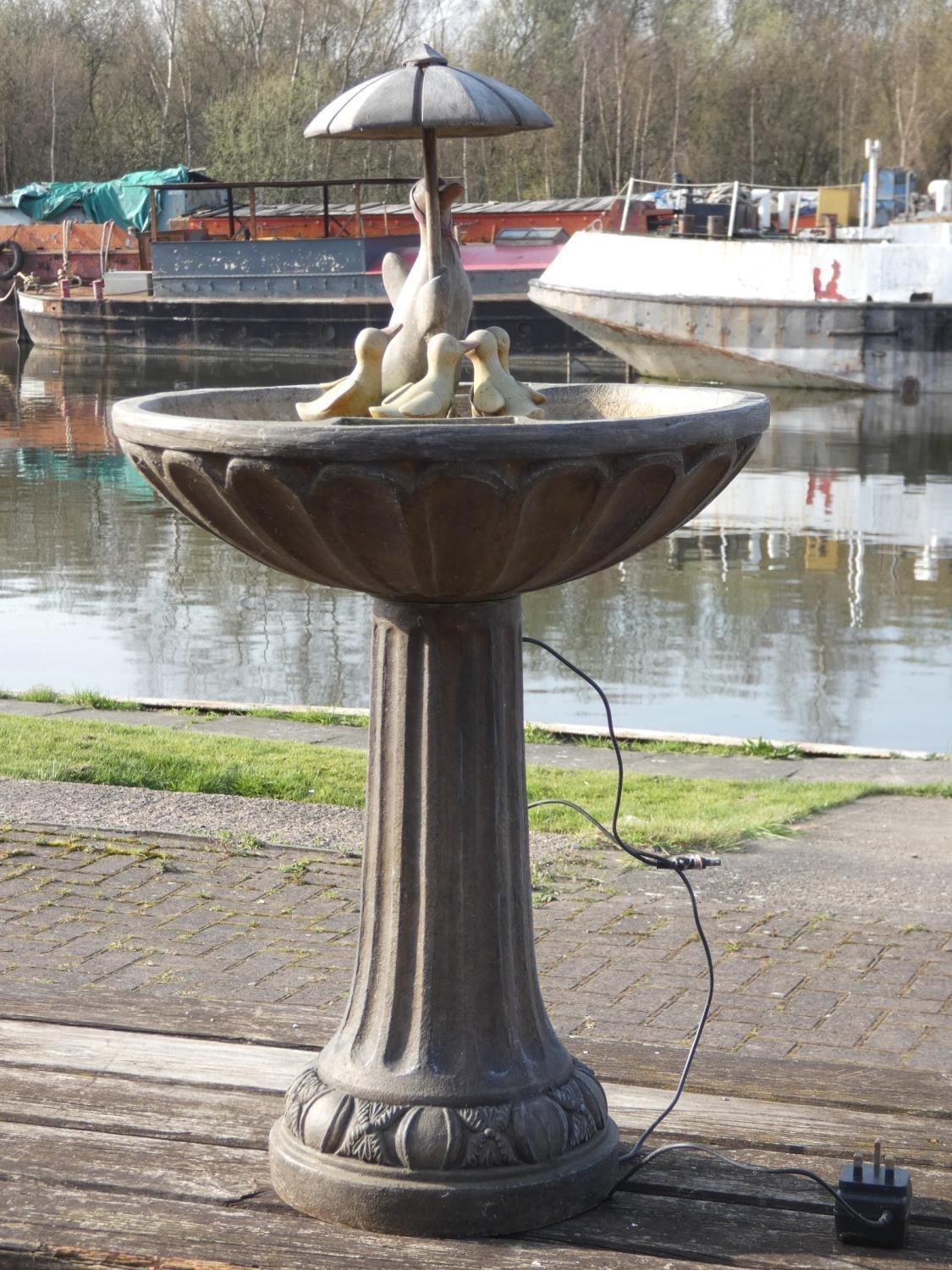 A solar powered, duck family water fountain, 84cmx48cm.