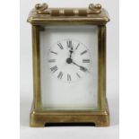 A brass carriage time piece, the white enamel dial unsigned, height with handle raised 14 cm.