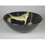 Ron Green, a black glazed stoneware bowl with white detail, diameter 26 cm, together with a dark