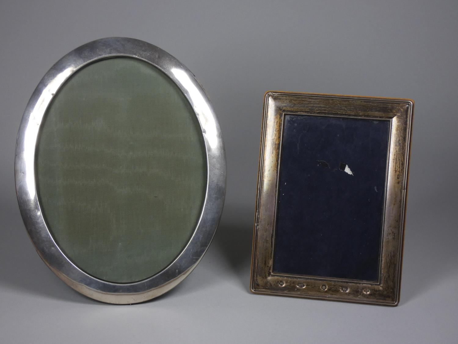 An oval silver photograph frame, Birmingham 1916, 24 x 19 cm and another London 2000, Millennium