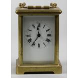 A French brass carriage time piece, the white enamel dial unsigned, the movement stamped France,