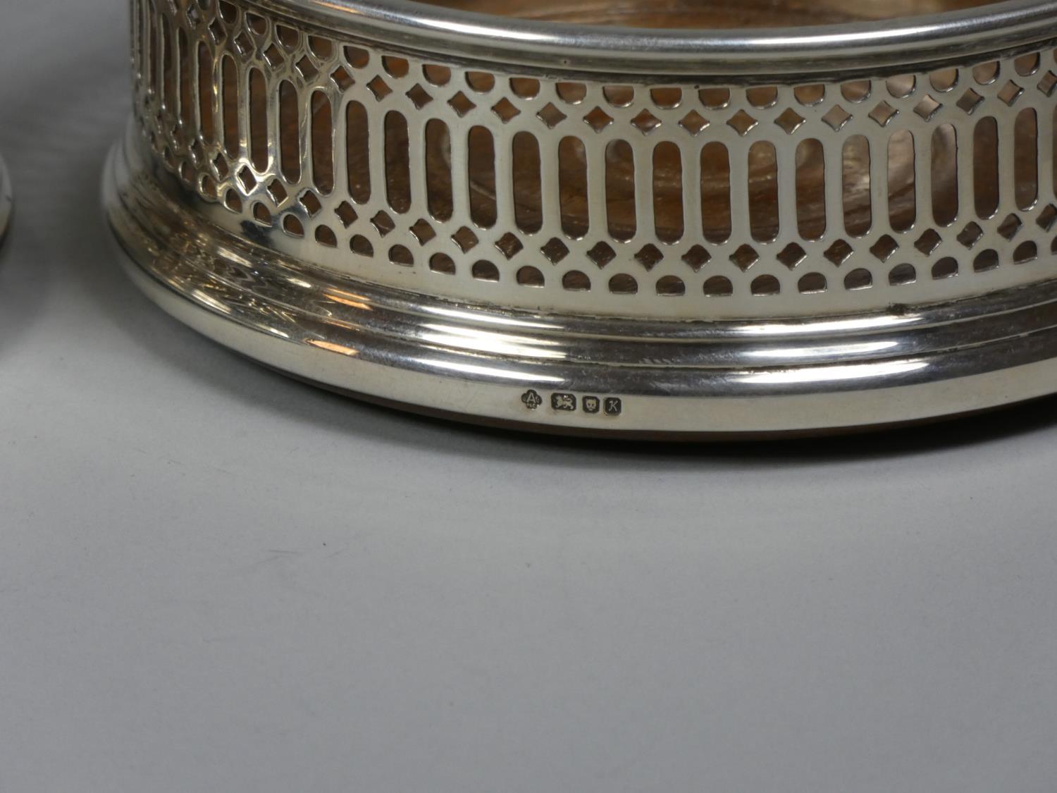 A pair of silver bottle coasters, London 1984, with pierced border and turned mahogany base, - Image 3 of 3