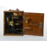 Fred. J. Cox, Eastbourne, a Victorian brass and cast iron microscope, with three different lens,