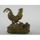 A French gilt metal musical box/desk stand, in the form of a cockerel with inkwell and pen tray,