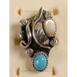 A Navaho silver and turquoise bangle, c.1980's, set with two matrix stones in a floral design,