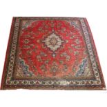 A large Persian wool rug, decorated with a red field and foliage border, 400 x 320 cm