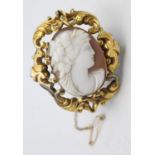 A Victorian gold mounted shell cameo brooch, depicting a Bacchanalian lady, scroll mount, 5 x 4 cm.
