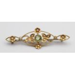 An Edwardian gold, peridot and half pearl bar brooch, set with a mixed cut stone, 45mm, 3 gms.