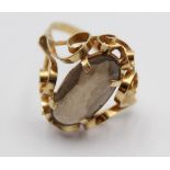 A continental smokey quartz dress ring, stamped 585, claw set with an oval mixed cut stone, size O