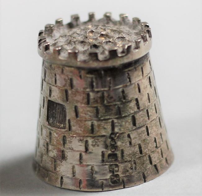 A novelty silver cast thimble, Dublin 1993, in the form of a castle, as et of six rat tail coffee