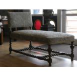An Edwardian oak day bed, with upholstered base and back, barley twist supports and stretchers,