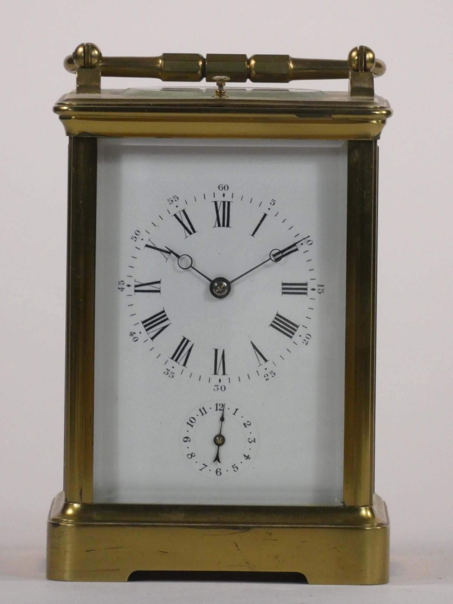 A brass carriage striking, repeating and alarm clock, the white enamel dial unsigned, subsidiary
