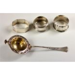 A Continental 800 standard silver tea strainer and three English silver napkin rings, 2.5 oz (4).
