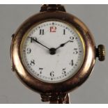 A 9ct rose gold ladies manual wind wristwatch, London 1910, the white enamel dial with red 12,