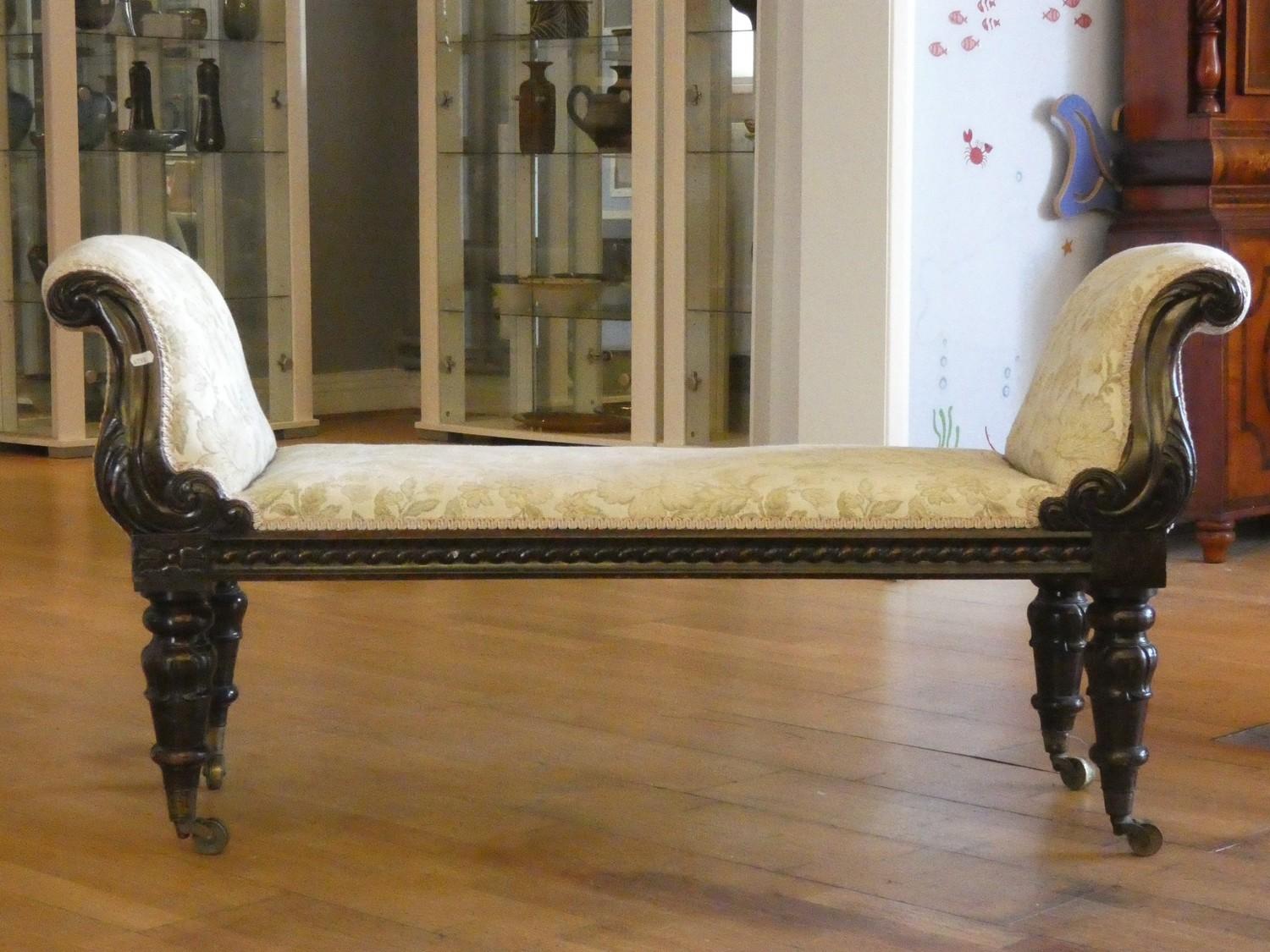 A Victorian mahogany window seat, with upholstered set and arms, raised on brass castors, 130 x 43 x