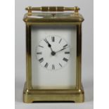 A large brass repeating carriage clock, the white enamel dial unsigned, the movement striking the