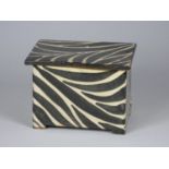 Unknown, a black glazed zebra pattern clay box, height 10 cm, together with two matching plates,