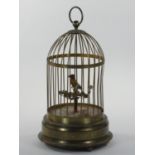 A mid century gilt metal musical automaton, in the form of a bird singing in a cage, stamped Made in