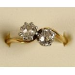 An 18ct gold two stone diamond ring, claw set with old cut stones weighing approximately 0.50cts