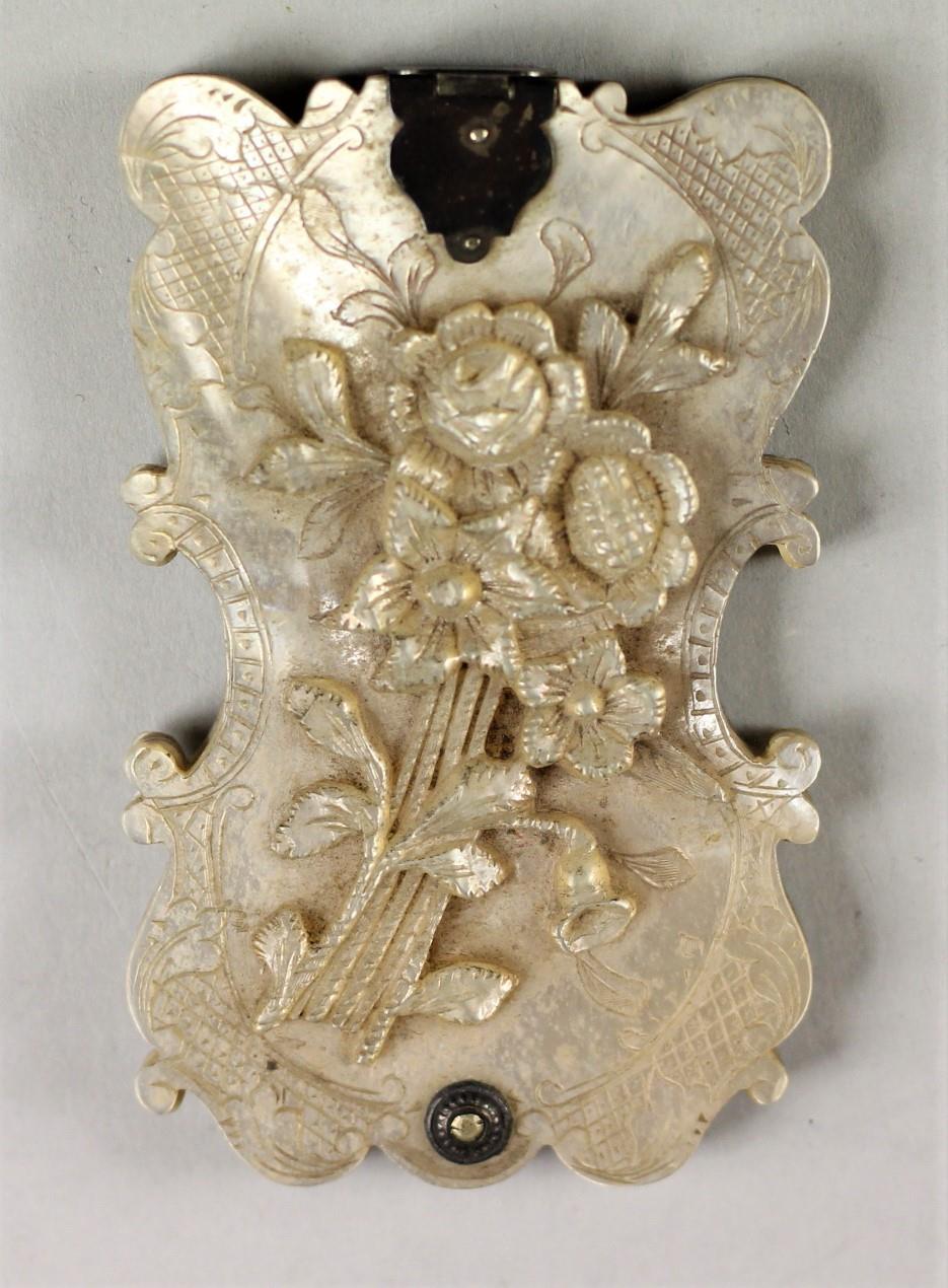 A Victorian silver mounted carved mother of pearl aide memoire, the front carved with a bouquet of