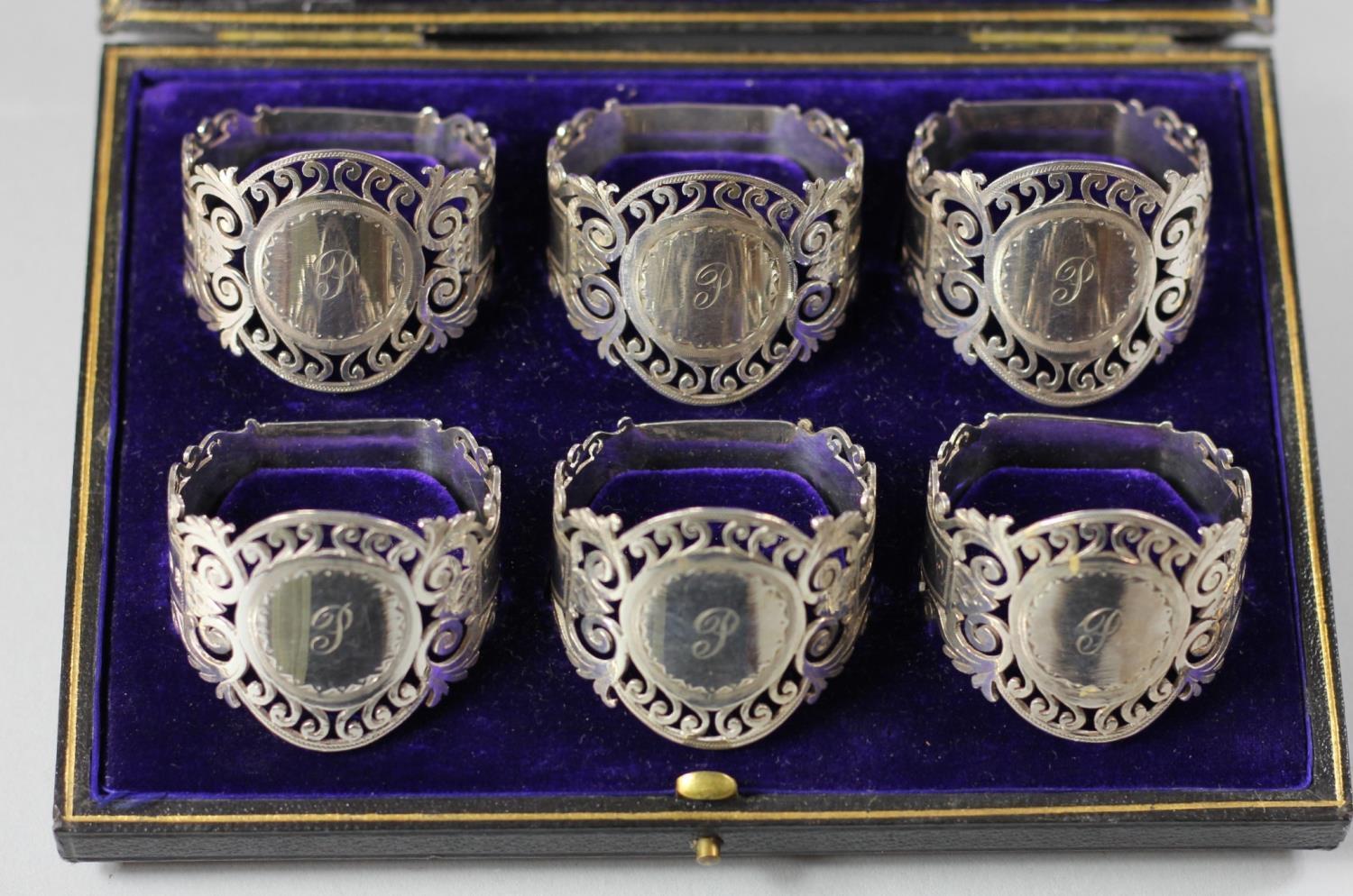 An Edwardian silver set of six napkin rings, Sheffield 1908, of pierced and engraved form, each