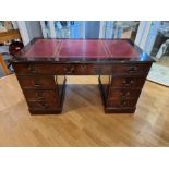 A mahogany pedestal desk, with red leather inserts, three freize drawers over three drawer