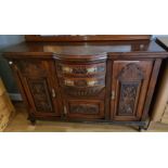 An Edwardian mahogany sideboard, with carved decoration, two central drawers over a cupboard,