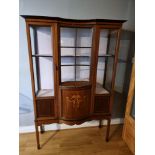 An Edwardian mahogany glazed display cabinet with shaped central section over a cupboard (left
