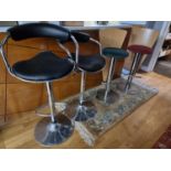 A pair of chrome bar stools and a laminate wood pair