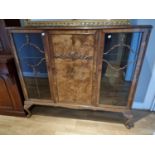 A walnut display cabinet, with glazed doors, raised on cabriole legs, 135 x 35 x 117 cm