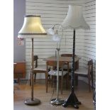 A turned wood standard lamp with fabric shade together with a similar standard lamp and a
