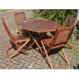 A stained hardwood folding garden dining table, and four matching chairs 107 cm diameter (5)