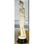 A figure of a semi-nude lady on a painted black plinth, 80 cm